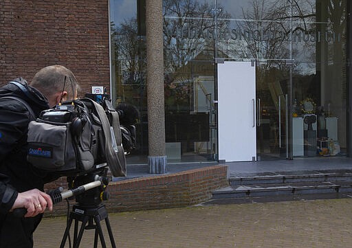 A cameraman films the glass door which was smashed during a break-in at the Singer Museum in Laren, Netherlands, Monday March 30, 2020. Police are investigating a break-in at a Dutch art museum that is currently closed because of restrictions aimed at slowing the spread of the coronavirus, the museum and police said Monday. (AP Photo/Peter Dejong)