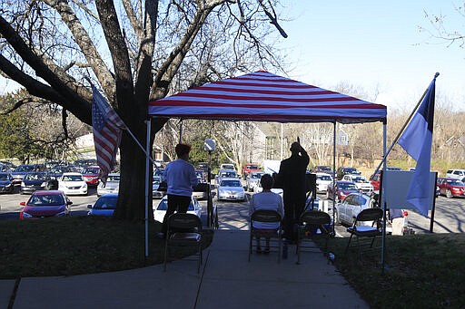 Pastor Lee leads a parking lot service at the Immanuel Lutheran Church In Lawrence, Kan., Sunday, March 29, 2020. The church plans two &quot;Praise in the Parking Lot&quot; services on Easter due to the coronavirus outbreak. (AP Photo/Orlin Wagner)