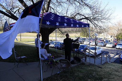 Pastor Lee leads a parking lot service at the Immanuel Lutheran Church In Lawrence, Kan., Sunday, March 29, 2020. The church plans two &quot;Praise in the Parking Lot&quot; services on Easter due to the coronavirus outbreak. (AP Photo/Orlin Wagner)