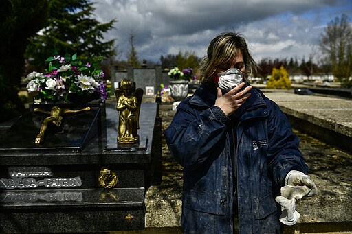 Undertaker Mari Carmen Serrador, 53 years old, protecting herself with a mask at Salvador cemetery during the coronavirus outbreak, near to Vitoria, northern Spain, Monday, March 30, 2020. The new coronavirus causes mild or moderate symptoms for most people, but for some, especially older adults and people with existing health problems, it can cause more severe illness or death. AP Photo/Alvaro Barrientos)