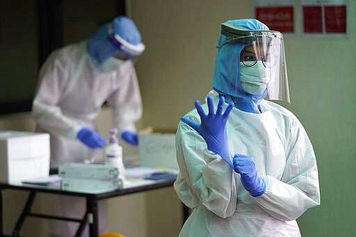 Health workers prepare to conduct a drive-through COVID-19 test for people at KPJ Damansara Specialist Hospital, in Petaling Jaya, Malaysia, Monday, March 30, 2020. The Malaysian government issued a restricted movement order to the public till April 14, to help curb the spread of the new coronavirus. The new coronavirus causes mild or moderate symptoms for most people, but for some, especially older adults and people with existing health problems, it can cause more severe illness or death. (AP Photo/Vincent Thian)