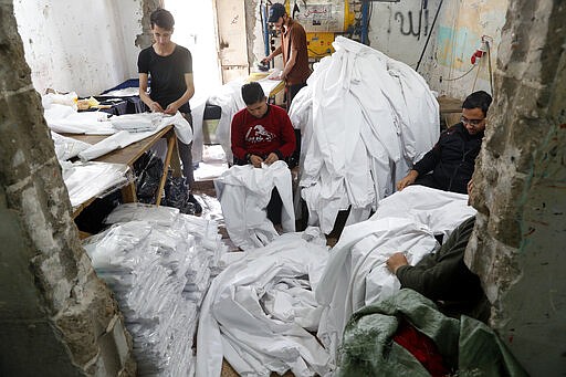 Palestinians make protective overalls meant to shield people from the coronavirus, to be exported to Israel, at a local factory, in Gaza City, Monday, March 30, 2020. (AP Photo/Adel Hana)