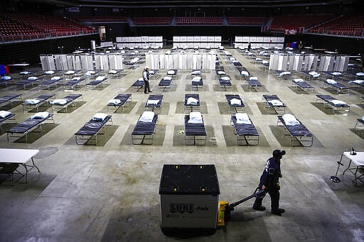 A worker moves items at a Federal Medical Station for hospital surge capacity set up at Temple University's Liacouras Center in Philadelphia, Monday, March 30, 2020. (AP Photo/Matt Rourke)