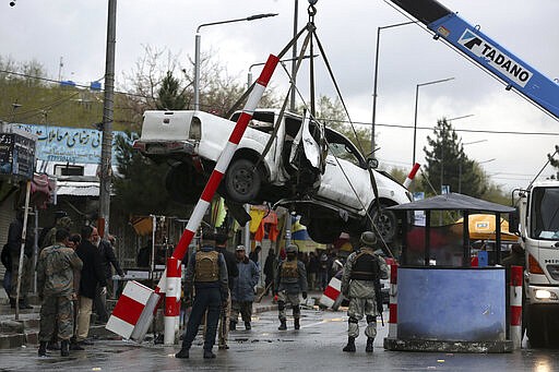 A damaged vehicle is removed from the site of a bomb explosion in Kabul, Afghanistan, Monday, March 30, 2020.  A sticky bomb attached to the vehicle detonated, according to Firdaus Faramraz, spokesman for the Kabul police chief. (AP Photo/Rahmat Gul)