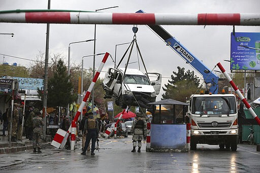 A damaged vehicle is removed from the site of a bomb explosion in Kabul, Afghanistan, Monday, March 30, 2020.  A sticky bomb attached to the vehicle detonated, according to Firdaus Faramraz, spokesman for the Kabul police chief. (AP Photo/Rahmat Gul)