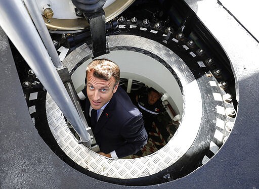 FILE - In this July 12, 2019 file photo, French President Emmanuel Macron gets out of the new French nuclear-powered submarine &quot;Suffren&quot; in Cherbourg, north-western France. Stealthily cruising the ocean deeps, deliberately hiding from the world now in turmoil, the crews of nuclear-armed submarines may be among the last pockets of people anywhere who are still blissfully unaware of how the coronavirus pandemic is turning life upside down. The new coronavirus causes mild or moderate symptoms for most people, but for some, especially older adults and people with existing health problems, it can cause more severe illness or death. (Ludovic Marin/Pool via AP, File)