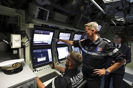 FILE - In this July 12, 2019 file photo, French navy commander Axel Roch poses in the navigation and operations center in the new nuclear-powered submarine &quot;Suffren&quot; in Cherbourg, north-western France. Stealthily cruising the ocean deeps, deliberately hiding from the world now in turmoil, the crews of nuclear-armed submarines may be among the last pockets of people anywhere who are still blissfully unaware of how the coronavirus pandemic is turning life upside down. The new coronavirus causes mild or moderate symptoms for most people, but for some, especially older adults and people with existing health problems, it can cause more severe illness or death. (Ludovic Marin/Pool via AP, File)