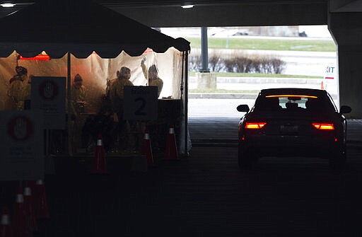 Health care workers see a patient in their vehicle at a COVID-19 drive thru assessment center at a Hospital in Mississauga, Ont., on Monday, March 30, 2020. (Nathan Denette/The Canadian Press via AP)