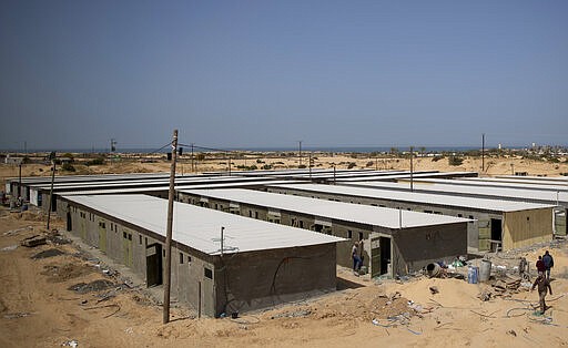 Palestinian workers construct a quarantine complex to be used for coronavirus cases, in the southern Gaza Strip, Monday, March 30, 2020. Fearing a widespread outbreak of the coronavirus, Gaza's Hamas leaders are racing to build two massive quarantine complexes as they try to prepare a territory poorly equipped to deal with a new health crisis (AP Photo/Khalil Hamra)