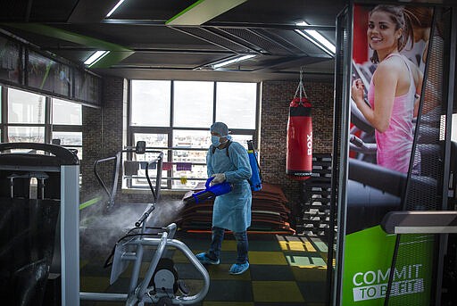 FILE - In this Sunday, March 15, 2020 file photo, A Palestinian Health worker sprays disinfectant as a precaution against the coronavirus in a gymnasium in Gaza City. The Gaza Strip has been largely cut off from the rest of the world for more than a decade by an Israeli-Egyptian blockade. But the coronavirus has found a way in. Fearing a widespread outbreak after nine confirmed cases, Gaza&#146;s Hamas leaders are racing to build two massive quarantine complexes and prepare the overcrowded territory not equipped to deal with a new health crisis. (AP Photo/Khalil Hamra, File)