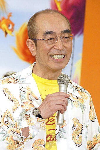 In this September 2012, photo, Japanese comedian Ken Shimura speaks during a campaign for an animation film in Tokyo. The nationally popular Japanese comedian, who said was drawing inspired from Jerry Lewis,  has died of the COVID-19 pneumonia, a first known celebrity victim of the virus in Japan. He was 70. Shimura had been treated at a Tokyo hospital, died of the virus Sunday, March 29, 2020, his agency, Izawa Office, said.(Kyodo News via AP)