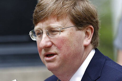 FILE - In this Tuesday, March 24, 2020, file photo, Mississippi Republican Gov. Tate Reeves speaks with reporters outside the Governor's Mansion to give an update on the current situation of the new coronavirus in the state and discuss Mississippi's ongoing response to slow the spread, in Jackson, Miss. In Mississippi, home to nearly 3 million people, Reeves has allowed most businesses to stay open, even restaurants, so long as they serve no more than 10 people at a time, amid the new coronavirus pandemic. (AP Photo/Rogelio V. Solis, File)