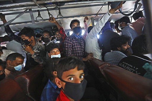 In this Friday, March 27, 2020, file photo, migrant daily wage laborers crowd a bus as they travel to their respective hometowns following a lockdown amid concern over spread of coronavirus in New Delhi, India. Over the past week, India&#146;s migrant workers - the mainstay of the country&#146;s labor force - spilled out of big cities that have been shuttered due to the coronavirus and returned to their villages, sparking fears that the virus could spread to the countryside. It was an exodus unlike anything seen in India since the 1947 Partition, when British colothe subcontinent, with the 21-day lockdown leaving millions of migrants with no choice but to return to their home villages. (AP Photo/Manish Swarup, File)