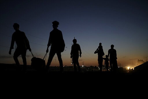 In this Saturday, March 28, 2020, file photo, a migrant laborer's family ia silhouetted as they proceed towards their village on foot, following a lockdown amid concern over spread of coronavirus in New Delhi, India. Over the past week, India&#146;s migrant workers - the mainstay of the country&#146;s labor force - spilled out of big cities that have been shuttered due to the coronavirus and returned to their villages, sparking fears that the virus could spread to the countryside. It was an exodus unlike anything seen in India since the 1947 Partition, when British colothe subcontinent, with the 21-day lockdown leaving millions of migrants with no choice but to return to their home villages. (AP Photo/Altaf Qadri, File)