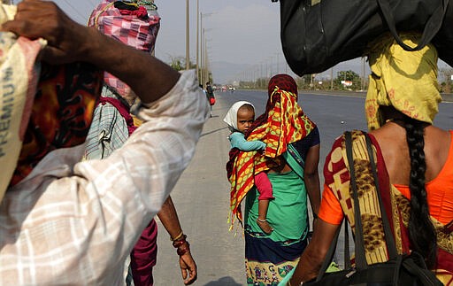 In this Sunday, March 29, 2020, file photo, migrant workers walk to their villages along the Mumbai Pune highway during 21-day countrywide lockdown in Mumbai, India. Over the past week, India&#146;s migrant workers - the mainstay of the country&#146;s labor force - spilled out of big cities that have been shuttered due to the coronavirus and returned to their villages, sparking fears that the virus could spread to the countryside. It was an exodus unlike anything seen in India since the 1947 Partition, when British colothe subcontinent, with the 21-day lockdown leaving millions of migrants with no choice but to return to their home villages. (AP Photo/Rajanish Kakade, File)