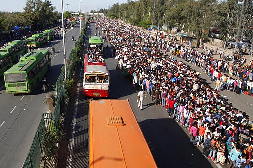 In this Saturday, March 28, 2020, file photo, Indian migrant laborers wait for buses provided by the government to transport them to their hometowns, following a lockdown amid concern over spread of coronavirus in New Delhi, India. Over the past week, India&#146;s migrant workers - the mainstay of the country&#146;s labor force - spilled out of big cities that have been shuttered due to the coronavirus and returned to their villages, sparking fears that the virus could spread to the countryside. It was an exodus unlike anything seen in India since the 1947 Partition, when British colothe subcontinent, with the 21-day lockdown leaving millions of migrants with no choice but to return to their home villages. (AP Photo, File)