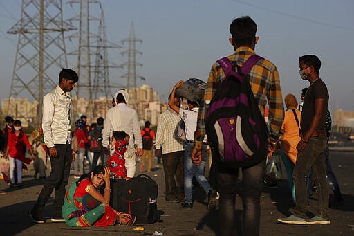 In this Saturday, March 28, 2020, file photo, an Indian migrant family waits for transportation to their village following a lockdown amid concern over spread of coronavirus in New Delhi, India. Over the past week, India&#146;s migrant workers - the mainstay of the country&#146;s labor force - spilled out of big cities that have been shuttered due to the coronavirus and returned to their villages, sparking fears that the virus could spread to the countryside. It was an exodus unlike anything seen in India since the 1947 Partition, when British colothe subcontinent, with the 21-day lockdown leaving millions of migrants with no choice but to return to their home villages. (AP Photo/Altaf Qadri, File)