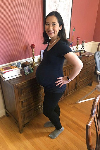 CORRECTS TO GEORGE WASHINGTON UNIVERSITY, NOT GEORGETOWN - In this March 30, 2020 photo, Dr. Leana Wen poses for a photo in her Baltimore home. Wen, a George Washington University public health specialist, who is pregnant and due to give birth soon, says she wants answers as a physician and as a patient to her concerns over the coronavirus. Her greatest fear is developing a COVID-19 infection or symptoms that would force her to be separated from her newborn for days or weeks. &#147;I would only be able to see my baby through a glass window. ... That&#146;s the one that gives me nightmares.&#148; (Courtesy Dr. Leana Wen via AP)