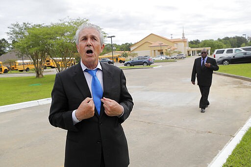 Timothy Spell, father of Pastor Tony Spell, talks to reporters after services at the Life Tabernacle Church in Central, La., Sunday, March 29, 2020. Tony Spell has defied a shelter-in-place order by Louisiana Gov. John Bel Edwards, due to the new coronavirus pandemic, and continues to hold church services with hundreds of congregants. (AP Photo/Gerald Herbert)