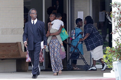 Congregants exit after services at the Life Tabernacle Church in Central, La., Sunday, March 29, 2020. Pastor Tony Spell has defied a shelter-in-place order by Louisiana Gov. John Bel Edwards, due to the new coronavirus pandemic, and continues to hold church services with hundreds of congregants. (AP Photo/Gerald Herbert)