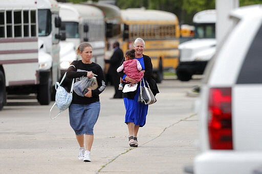 Congregants leave after services at the Life Tabernacle Church in Central, La., Sunday, March 29, 2020. Pastor Tony Spell has defied a shelter-in-place order by Louisiana Gov. John Bel Edwards, due to the new coronavirus pandemic, and continues to hold church services with hundreds of congregants. (AP Photo/Gerald Herbert)