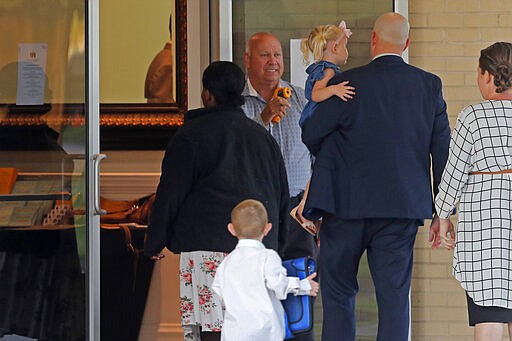 A man takes temperature scans as congregants arrive for evening service at the Life Tabernacle Church in Central, La., Tuesday, March 31, 2020. Pastor Tony Spell held services despite being charged with misdemeanors today, for holding services against Gov. John Bel Edwards shelter-in-place order due to the new coronavirus pandemic. (AP Photo/Gerald Herbert)