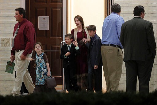 Congregants leave after an evening service at Life Tabernacle Church in Central, La., Tuesday, March 31, 2020. Pastor Tony Spell held services despite being previously charged with misdemeanors for holding services despite a ban on gatherings amid the coronavirus pandemic. (AP Photo/Gerald Herbert)