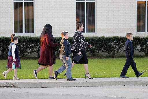 Congregants arrive for evening service at the Life Tabernacle Church in Central, La., Tuesday, March 31, 2020. Pastor Tony Spell held services despite being charged with misdemeanors today, for holding services against Gov. John Bel Edwards shelter-in-place order due to the new coronavirus pandemic. (AP Photo/Gerald Herbert)