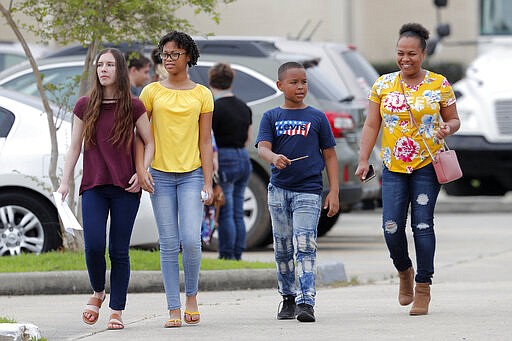 Congregants leave the Life Tabernacle Church in Central, La., after services Sunday, March 29, 2020. Pastor Tony Spell has defied a shelter-in-place order by Louisiana Gov. John Bel Edwards, due to the new coronavirus pandemic, and continues to hold church services with hundreds of congregants. (AP Photo/Gerald Herbert)