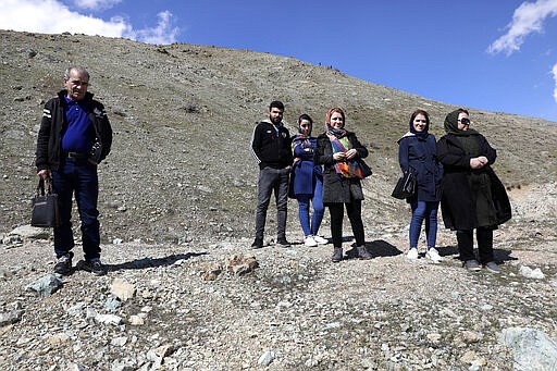 People look out over Tehran from the foothills of the Alborz mountain range north of the city as they spend their New Year, or Nowruz, holidays, Iran, Tuesday, March 31, 2020. In recent days, Iran which is battling the worst new coronavirus outbreak in the region, has ordered the closure of nonessential businesses and banned intercity travels aimed at preventing the virus' spread.   (AP Photo/Vahid Salemi)