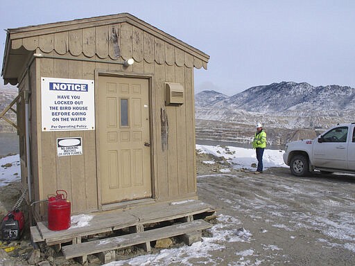 FILE - In this Dec. 14, 2016, file photo, Montana Resources' Mark Thompson stands on the bank of the Berkeley Pit behind a hut used to watch for birds that try to land in the toxic water in Butte, Mont. At the Berkeley Pit, Montana Resources plans to keep up efforts that drive away almost all birds, in part to avoid a repeat of the negative publicity and community backlash that followed the 2016 bird kill, according to Thompson, the manager of environmental affairs. (AP Photo/Matt Volz, File)