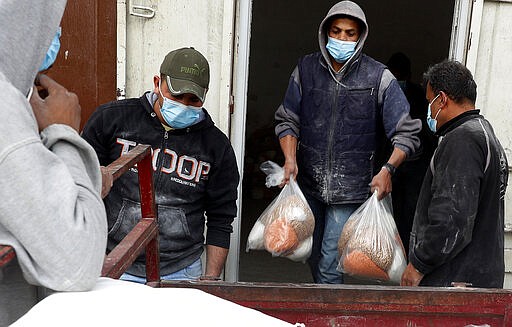 Palestinian workers unloads food supplies distributed by the United Nations Relief and Works Agency (UNRWA) for poor refugee families, at the Sheikh Redwan neighborhood of Gaza City, Tuesday, March 31, 2020. The United Nations has resumed food deliveries to thousands of impoverished families in the Gaza Strip after a three-week delay caused by fears of the coronavirus. UNRWA, provides staples like flour, rice, oil and canned foods to roughly half of Gaza&#146;s 2 million people. (AP Photo/Adel Hana)