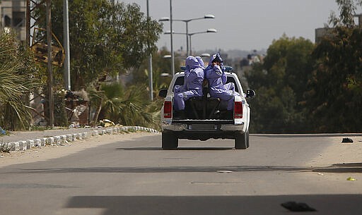 Palestinian security police, wearing protective gear, patole on the street in the northern Gaza Strip, Monday, March 30, 2020. (AP Photo/Hatem Moussa)