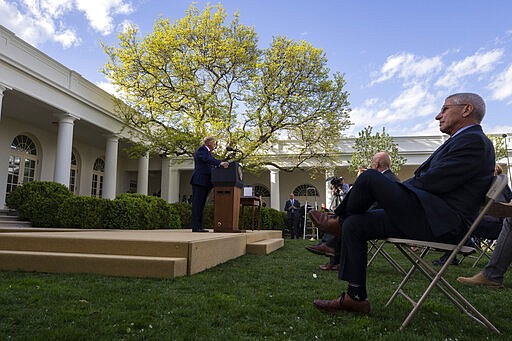 President Donald Trump speaks as Dr. Anthony Fauci, director of the National Institute of Allergy and Infectious Diseases, is seated right, about the coronavirus in the Rose Garden of the White House, Monday, March 30, 2020, in Washington. (AP Photo/Alex Brandon)