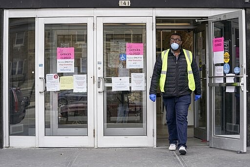 FILE - In this March 30, 2020, file photo, a worker leaves the the Frank P. Zeidler Municipal Building in Milwaukee. Gov. Tony Evers asked President Donald Trump on Tuesday, March 31, 2020 to issue a major disaster declaration for the state of Wisconsin due to the coronavirus pandemic, as unemployment claims hit a daily high and the state's health secretary warned lawmakers that Medicaid enrollments were going to increase dramatically. (AP Photo/Morry Gash, File)