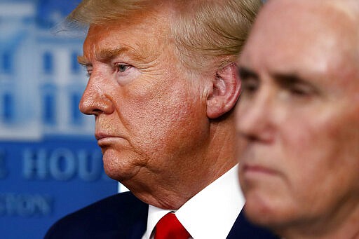 President Donald Trump and Vice President Mike Pence listen during a briefing about the coronavirus in the James Brady Press Briefing Room of the White House, Tuesday, March 31, 2020, in Washington. (AP Photo/Alex Brandon)