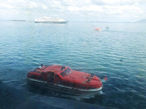 In this Saturday, March 28, 2020 photo made available by Juan Huergo, a tender approaches the Zaandam, a Holland America cruise ship off Panama. The tender transferred passengers from the Zaandam to the Rotterdam (background). The Zaandam has many passengers experiencing flu-like symptoms. Florida Gov. Ron DeSantis said Monday, March 30, 2020, that it would be a mistake to bring passengers from the Zandaam to Florida. He said the area's hospital beds need to be saved for residents and not &quot;foreign nationals.&quot; (Juan Huergo via AP)