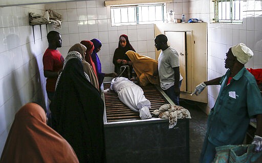 Relatives wash the body of 13-year-old Yasin Hussein Moyo prior to burial, at the Kariakor cemetery in Nairobi, Kenya Tuesday, March 31, 2020. The family of a 13-year-old boy is in mourning after police in Kenya's capital are accused of shooting him dead while enforcing a coronavirus curfew. Kenya&#146;s police inspector general has ordered an investigation into the boy&#146;s death by &#147;stray bullet,&#148; including a forensic analysis of all firearms held by officers at the scene. (AP Photo/Brian Inganga)