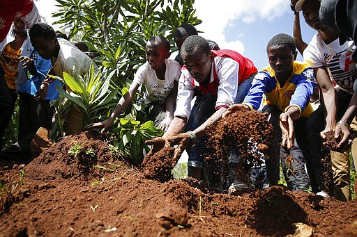 Relatives and friends bury 13-year-old Yasin Hussein Moyo at the Kariakor cemetery in Nairobi, Kenya Tuesday, March 31, 2020. The family of a 13-year-old boy is in mourning after police in Kenya's capital are accused of shooting him dead while enforcing a coronavirus curfew. Kenya&#146;s police inspector general has ordered an investigation into the boy&#146;s death by &#147;stray bullet,&#148; including a forensic analysis of all firearms held by officers at the scene. (AP Photo/Brian Inganga)