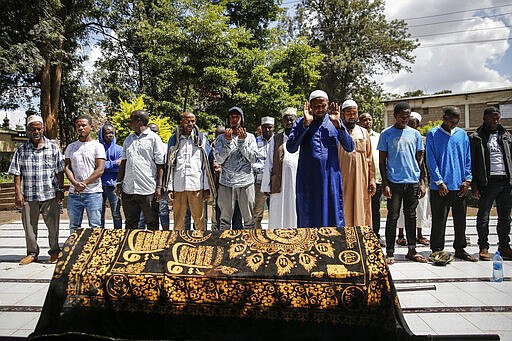 Relatives and friends pray over the body of 13-year-old Yasin Hussein Moyo at his burial, at the Kariakor cemetery in Nairobi, Kenya Tuesday, March 31, 2020. The family of a 13-year-old boy is in mourning after police in Kenya's capital are accused of shooting him dead while enforcing a coronavirus curfew. Kenya&#146;s police inspector general has ordered an investigation into the boy&#146;s death by &#147;stray bullet,&#148; including a forensic analysis of all firearms held by officers at the scene.  (AP Photo/Brian Inganga)