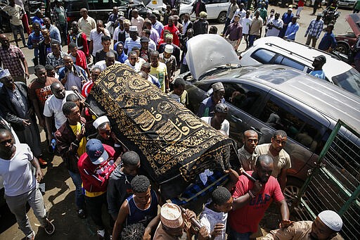 Relatives carry the body of 13-year-old Yasin Hussein Moyo for burial, at the Kariakor cemetery in Nairobi, Kenya Tuesday, March 31, 2020. The family of a 13-year-old boy is in mourning after police in Kenya's capital are accused of shooting him dead while enforcing a coronavirus curfew. Kenya&#146;s police inspector general has ordered an investigation into the boy&#146;s death by &#147;stray bullet,&#148; including a forensic analysis of all firearms held by officers at the scene. (AP Photo/Brian Inganga)