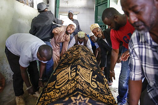 Relatives carry the body of 13-year-old Yasin Hussein Moyo for burial, at the Kariakor cemetery in Nairobi, Kenya Tuesday, March 31, 2020. The family of a 13-year-old boy is in mourning after police in Kenya's capital are accused of shooting him dead while enforcing a coronavirus curfew. Kenya&#146;s police inspector general has ordered an investigation into the boy&#146;s death by &#147;stray bullet,&#148; including a forensic analysis of all firearms held by officers at the scene. (AP Photo/Brian Inganga)