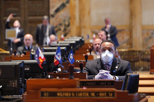 State Rep. Vincent Pierre, D-Dist. 44, wears a mask and gloves as legislators convene in a limited number while exercising social distancing, due to the new coronavirus pandemic, at the state Capitol in Baton Rouge, La., Tuesday, March 31, 2020. They assembled briefly since it was the last day bills cold be introduced during the legislative session. (AP Photo/Gerald Herbert)