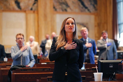 State Rep. Paula Davis, R-Dist. 69, holds holds her hand to her heart for the Pledge of Allegiance, as legislators convene in a limited number while exercising social distancing, due to the new coronavirus pandemic, at the State Capitol in Baton Rouge, La., Tuesday, March 31, 2020. They assembled briefly on the last day bills could be introduced during the legislative session. (AP Photo/Gerald Herbert)