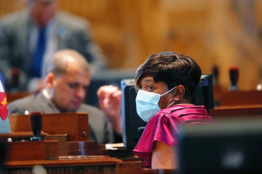 State Rep. Denise Marcelle, D-Dist. 61, wears a mask as legislators convene in a limited number while exercising social distancing, due to the new coronavirus pandemic, at the State Capitol in Baton Rouge, La., Tuesday, March 31, 2020. They assembled briefly on the last day bills could be introduced during the legislative session. (AP Photo/Gerald Herbert)