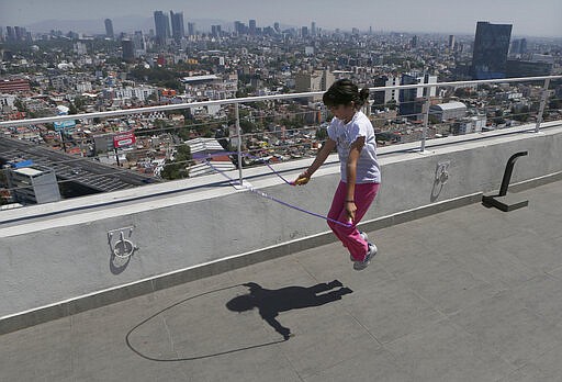 Staying home after her school canceled classes due to the spread of the new coronavirus, Sofia Cortes jumps rope on the roof of a building in Mexico City,Tuesday, March 31, 2020. Mexico's government has broadened its shutdown of &#147;non essential activities,&#148; and prohibited gatherings of more than 50 people as a way to help slow down the spread of COVID-19. The one-month emergency measures will be in effect from March 30 to April 30. (AP Photo/Marco UGarte)