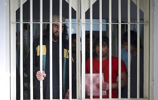 FILE - In this Dec. 14, 2019 file photo, jailed Taliban are seen inside the Pul-e-Charkhi jail in Kabul, Afghanistan. A three-member Taliban technical team arrived Tuesday, March 31, 2020, in the Afghan capital to oversee the release of their prisoners as part of a peace deal signed by the Taliban and the U.S., a spokesman for the insurgent group said. (AP Photo/Rahmat Gul, File)