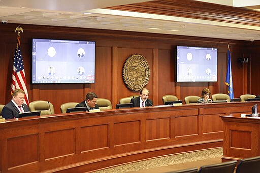 In this photo provided by Patrick Callahan, House legislative leaders met on Monday, March 30, 2020, in the Capitol building in Pierre while most lawmakers joined through a teleconference committee. They were considering emergency bills pushed by Gov. Kristi Noem. (Patrick Callahan/South Dakota Broadcasters Association via AP)