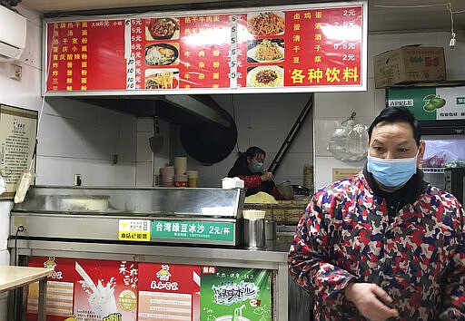 Stores owners of a store selling a local favorite &quot;reganmian,&quot; or &quot;hot dry noodles,&quot; prepare takeaway orders in Wuhan in central China's Hubei province, Tuesday, March 31, 2020. The reappearance of Wuhan's favorite noodles is a tasty sign that life is slowly returning to normal in the Chinese city at the epicenter of the global coronavirus outbreak. The steady stream of customers buying bags of noodles smothered in peanut sauce testifies to a powerful desire to enjoy the familiar again after months of strict lockdown. (AP Photo/Olivia Zhang)