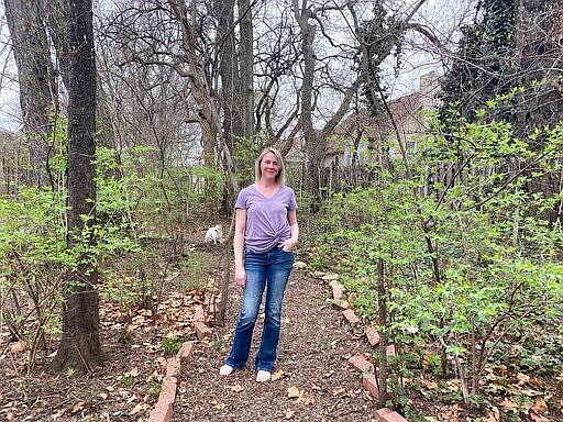 In this March 30, 2020 photo, Hollie Niblett is stands in her garden at her home in Overland Park, Kan. Amid the coronavirus outbreak, backyard gardens are turning into a getaway for the mind in chaotic times. (Maya Niblett via AP)